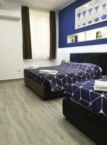 克罗托内Alex & Frank Apartment的一间卧室设有两张床和蓝色的墙壁