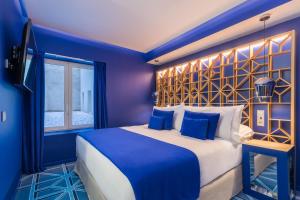马德里Room Mate Macarena – Gran Vía的蓝色的卧室设有一张大床和一个窗户