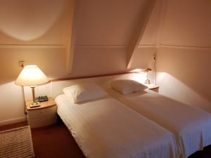 MarumBoetiek Hotel Marum的卧室配有一张带灯的白色大床