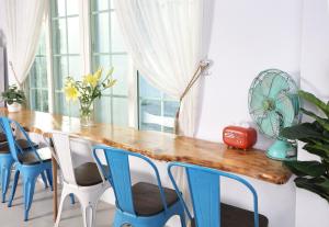 台东小逗民宿的一间带木桌和蓝色椅子的用餐室