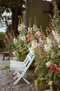 特雷勒堡Axatorpsgården的坐在鲜花花园中的白色长椅