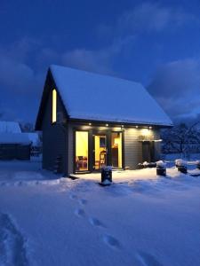 斯克伦达Skrundas namiņš的夜晚雪中的小房子
