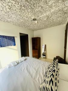 危地马拉安地瓜Casa ELA的卧室配有白色的床和天花板