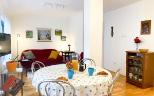 萨格勒布Apartment Mletačka的客厅配有桌子和红色沙发