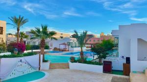 沙姆沙伊赫Badawia Sharm Resort的享有带游泳池和棕榈树的度假村的景致