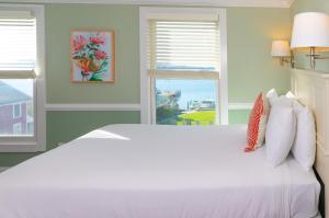 麦基诺岛Island House Hotel的窗户客房内的一张白色床