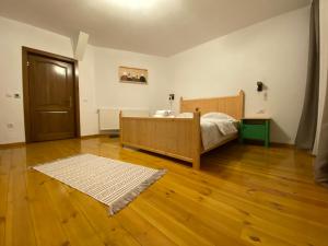 布朗Floare de Colț-Bran的一间卧室配有一张床,铺有木地板