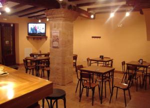 CerolleraHostal La Cerollera的餐厅设有桌椅和平面电视。