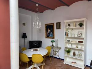 卡莫纳Casa Boutique Eros的一间设有白色桌子和黄色椅子的用餐室