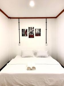 古雷德胡Hiraeth island home的卧室配有一张白色床,墙上挂有三张照片