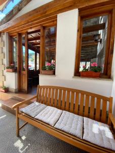 奥耶多Hostal Toscana的木凳,坐在带窗户的建筑前