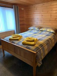 格伦德文Corrie Lodge, Glendevon的一间卧室配有一张黄色毛巾的床