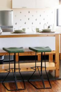 提华纳Coyote Lofts-Estacion Federal的厨房配有带2张绿色凳子的台面