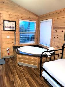 韦斯特波特Westport Inn Cabins的一间带浴缸的浴室,位于一个木墙客房内