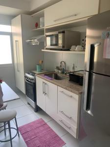 马塞约Apartamento em Maceió - JTR México的厨房配有白色橱柜和不锈钢冰箱