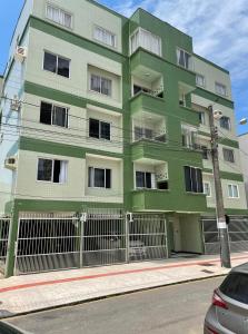 巴拉奈里奥-坎布里乌Apartamento amplo e completo no centro Balneário Camboriú的街道边的绿色建筑