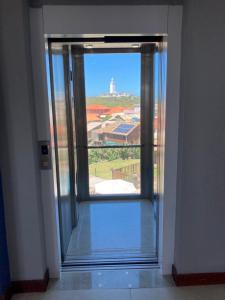 拉古纳Apto com vista para o mar e o farol - loft 323的开放式玻璃门,享有建筑的景色