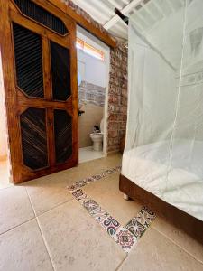 帕洛米诺Posada Gallinas的一间带木门和卫生间的卧室