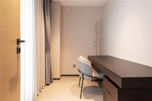 成都成都恺亚公馆服务式公寓的客房设有书桌、两把椅子和窗户。