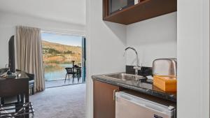 皇后镇Alpine Lakeside Studio的一个带水槽的厨房,享有庭院的景色