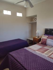 库拉布罗切罗镇Cabañas Y Departamentos Bettylu的一间卧室配有两张床和吊扇