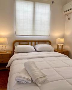 萨利纳斯Las Casitas en Salinas的卧室配有一张大白色床和窗户