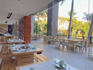 三亚三亚海棠湾万达嘉华度假酒店的餐厅设有木桌、椅子和窗户。