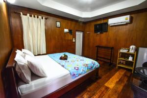 巴真府巴真府普鲁科萨度假村的一间卧室配有一张床和一台电视