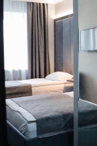 秋明图拉酒店的酒店客房设有两张床和窗户。