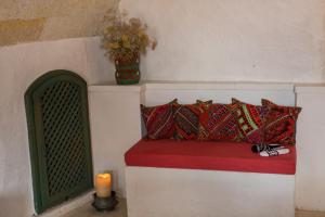 乌奇希萨尔卡帕多切城堡酒店的客房内的长凳配有枕头和蜡烛