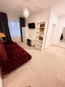 塔古玖COCHET BOUTIQUE的客厅配有红色沙发和电视
