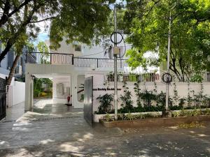 钦奈Hanu Reddy Residences - Nawab Habibullah Avenue的白色的建筑,设有种有树木的庭院