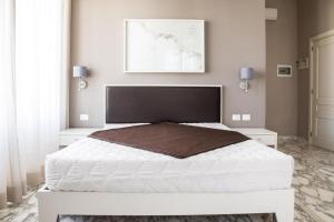 加利波利Faro Bianco Gallipoli - Suites & Apartments的卧室配有一张白色大床和两个白色橱柜。