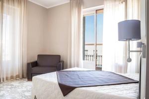 加利波利Faro Bianco Gallipoli - Suites & Apartments的卧室配有床、椅子和窗户。