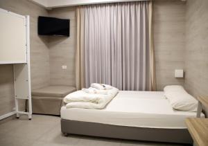 耶路撒冷HI拉宾 - 耶路撒冷旅舍的一间酒店客房,配有一张床和一台电视,还有一间客房