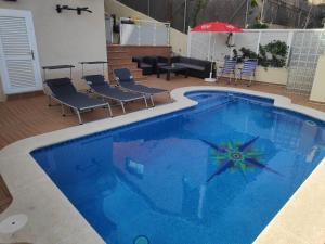 卡拉费尔BEACH HOUSE. CASA CON PISCINA PRIVADA的一个带椅子和遮阳伞的大型蓝色游泳池