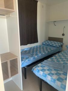 马达莱纳Abbatoggia Village的客房设有两张床和窗户。