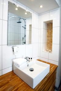 奥斯卡港Adels Hotel的白色的浴室设有水槽和镜子