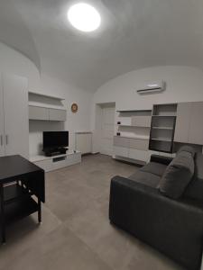 萨莱诺CASA VACANZE - ANTICO CONVENTO的客厅配有黑色沙发和桌子
