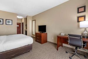 奥法隆Comfort Inn & Suites St Louis-O'Fallon的酒店客房配有一张床和一张带电脑的书桌
