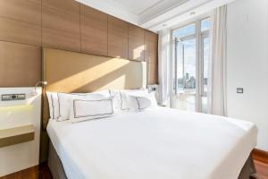 拉科鲁尼亚玛利亚皮塔美利亚酒店的卧室配有一张大白色床和窗户