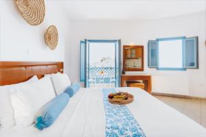 阿斯提帕莱亚镇安德罗梅塔度假酒店的一间卧室,配有一张床,上面放着一碗水果