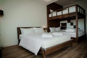 甲米镇Play Poshtel & Cafe'的卧室配有2张双层床和白色床单