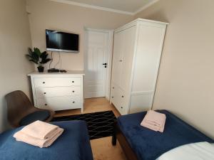 库多瓦-兹德鲁伊Apartament Lea w Kudowie Zdrój的一间卧室配有两张床、一个梳妆台和电视。