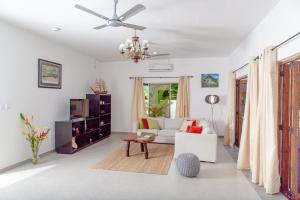 马埃岛Riverside Mount Simpson - Seychelles Island的带沙发和吊扇的客厅