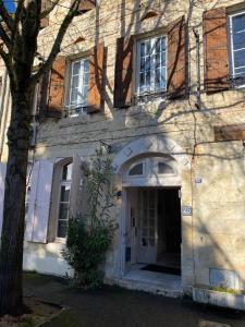 阿让Relais des Iles chambres d'hôtes的一座有白色门和树的建筑