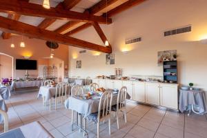 弗代纳渣油格兰德阿维农高尔夫酒店的一间带桌椅的餐厅和一间厨房