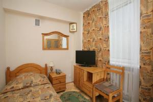 莫斯科大学卡亚酒店的一间卧室配有一张床、一台电视和一个窗口