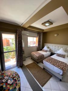 贝尼迈拉勒Hotel VELSATIS的酒店客房设有两张床和窗户。