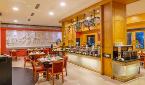 马杜赖Fortune Pandiyan Hotel, Madurai - Member ITC's Hotel Group的一间带桌椅和柜台的餐厅